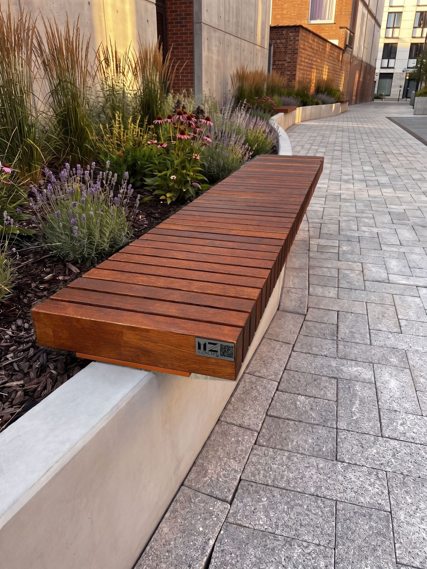 Banc public en lames d’afzélia posé sur un muret, le long d’une allée plantée