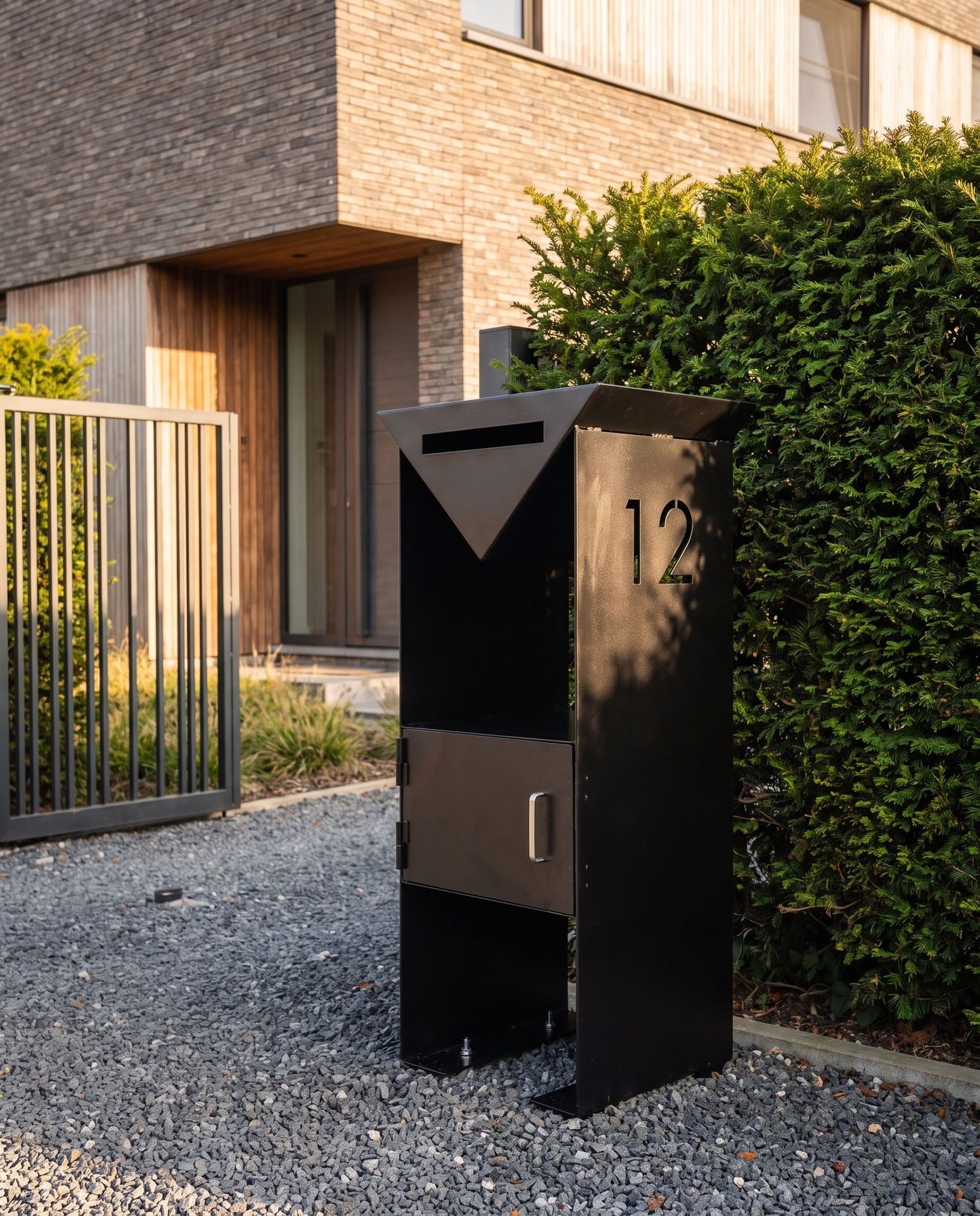 Boîte aux lettres en acier noir à l’entrée d’une maison, numéro découpé au laser